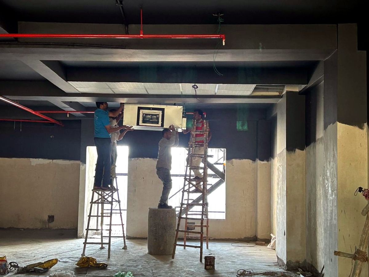 Crew lifting a ductable indoor unit into position